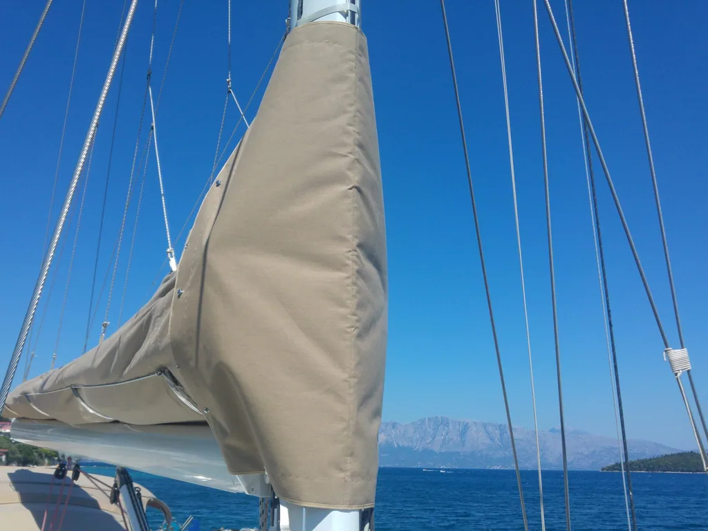 A cream lazy bag closed along the boom against open blue sea