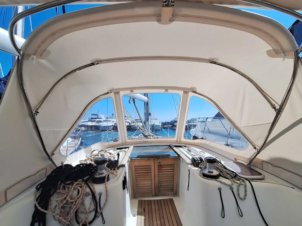 A tan sprayhood seen from the cockpit, looking forward down a teak deck