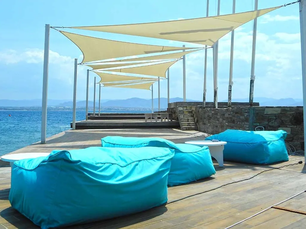 Cream shade sails over a waterside sun deck with beanbags