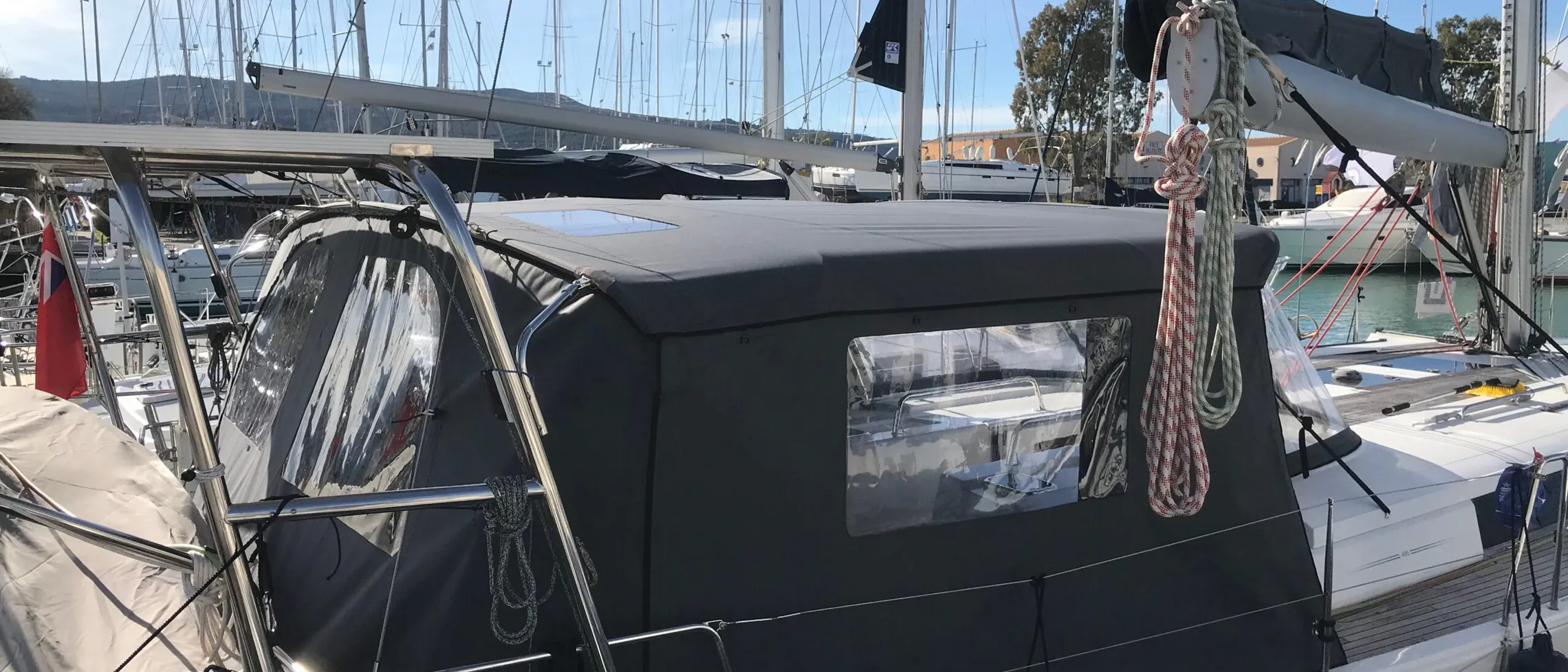 A dark cockpit enclosure with clear windows closing in the aft deck of a yacht