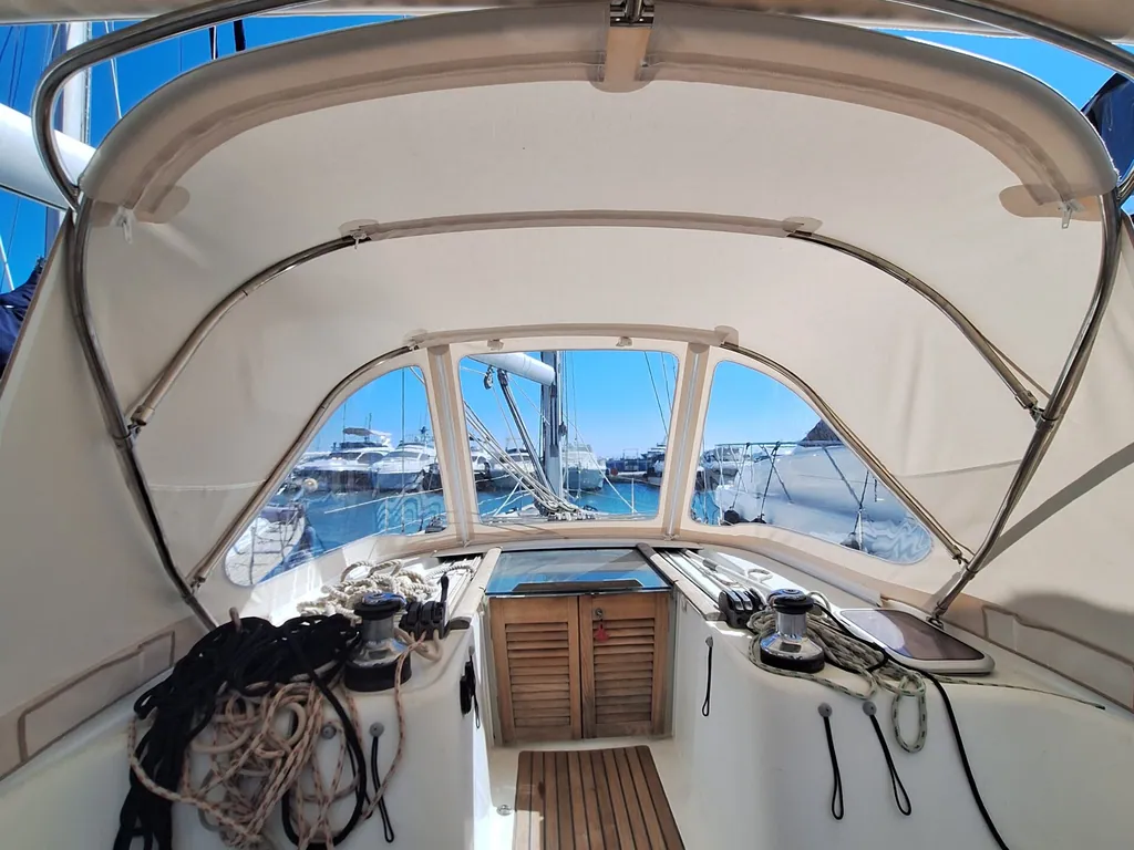 A tan sprayhood seen from the cockpit, looking forward down a teak deck