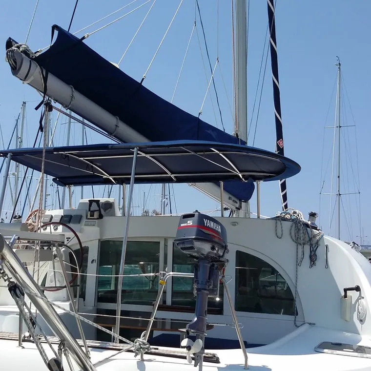 Navy bimini rigged over the cockpit of a catamaran in a marina