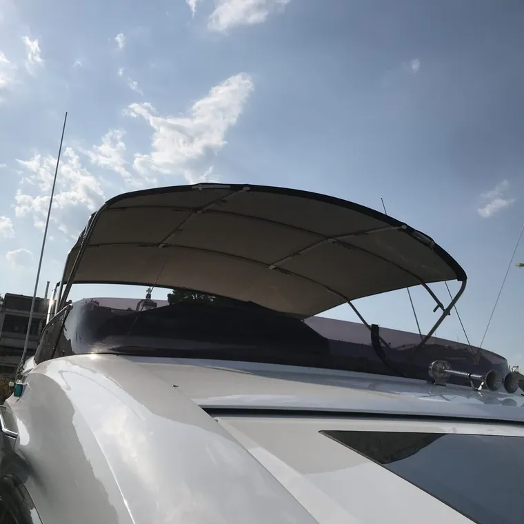 Motor yacht with a dark cover over the sun deck and windscreen