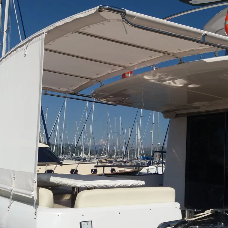 Cream bimini shading the cockpit seating and table of a yacht