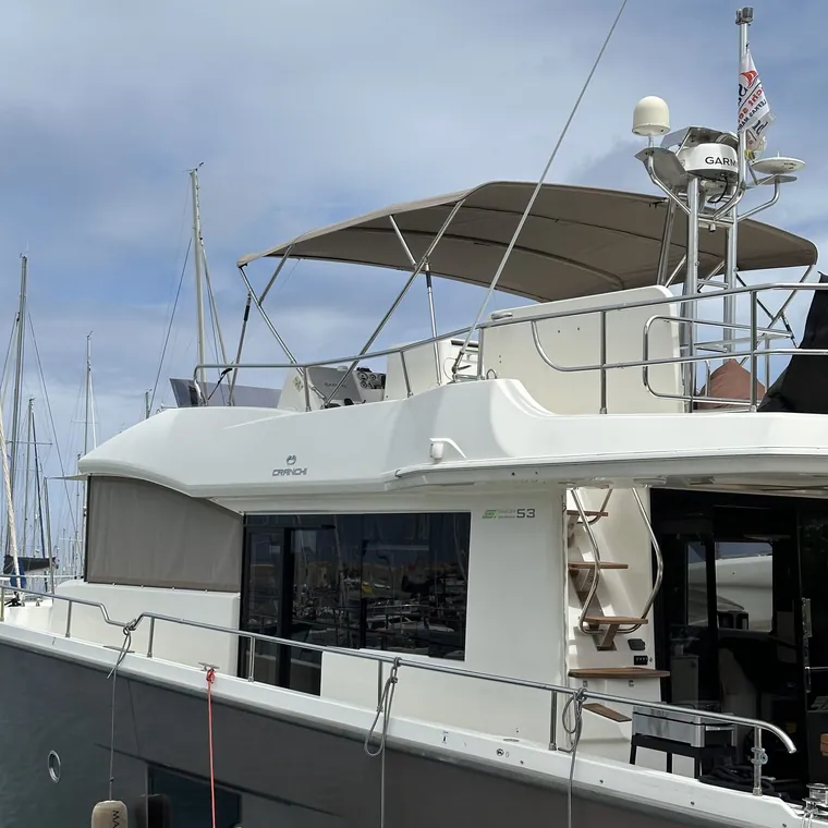 Motor yacht with a grey bimini over the flybridge helm