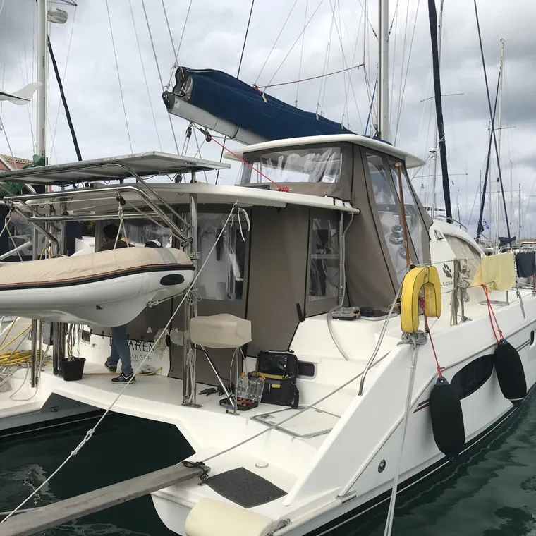 Catamaran cockpit enclosed under a bimini in a marina