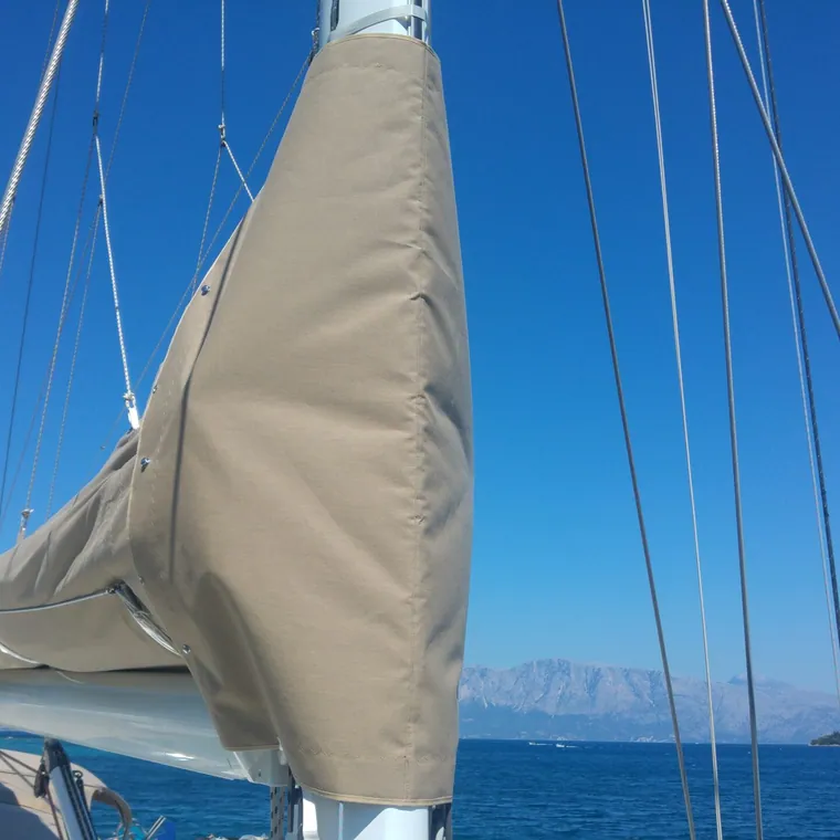 Cream lazy bag closed along the boom against open blue sea