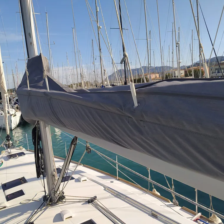 Grey lazy bag on the boom of a yacht alongside in a marina