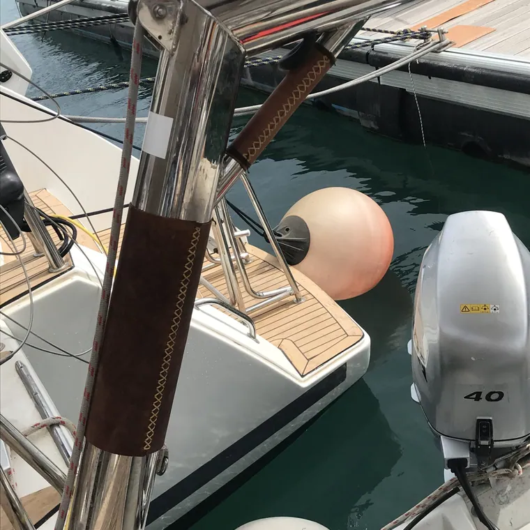 Stainless pushpit rail wrapped in dark brown leather aboard a boat