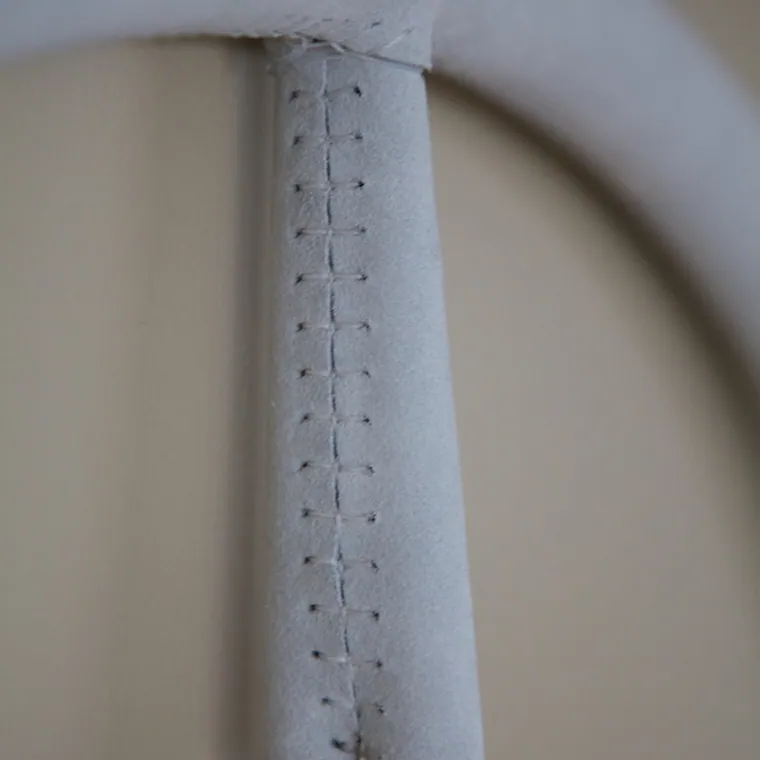 Pale leather wrapped and stitched around a stainless upright