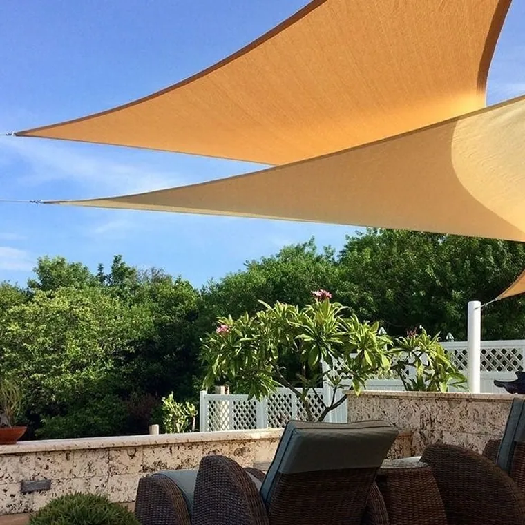 Terracotta shade sail over a terrace looking out to the sea