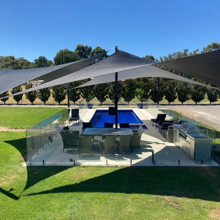 Dark shade sail over a pool bar and lawn at a villa