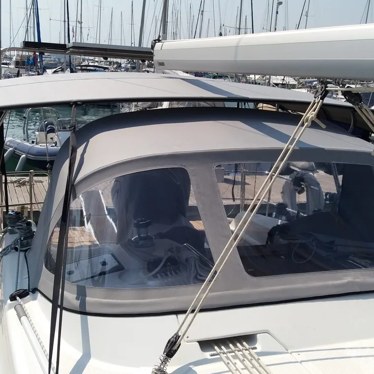 White sprayhood with clear windows fitted over the companionway of a yacht