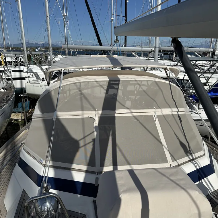 Sprayhood with navy trim over the companionway, marina behind