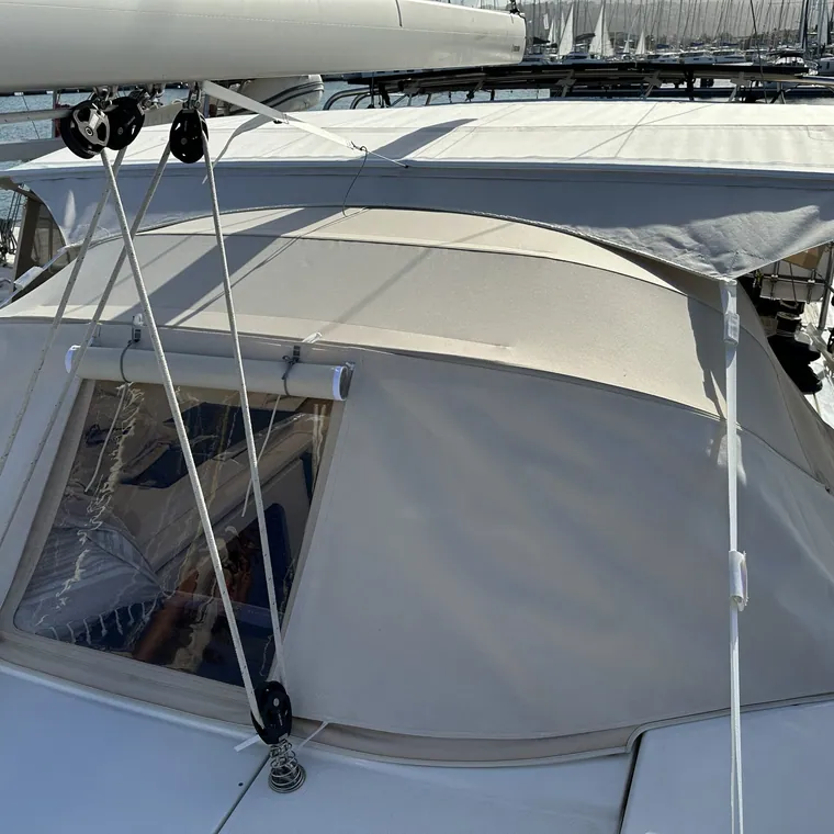 Sprayhood and side panel joined at the coachroof of a yacht