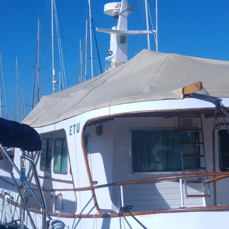 Motor yacht with the flybridge and helm station closed in under a fitted cover