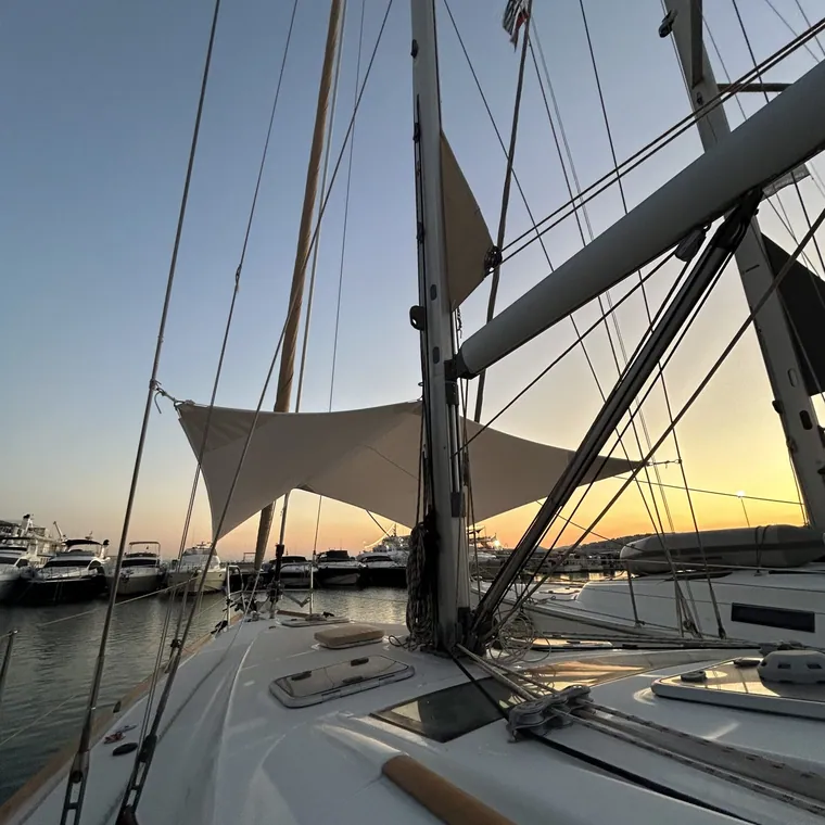 Shade sail over a yacht deck at sunset, rigging in silhouette