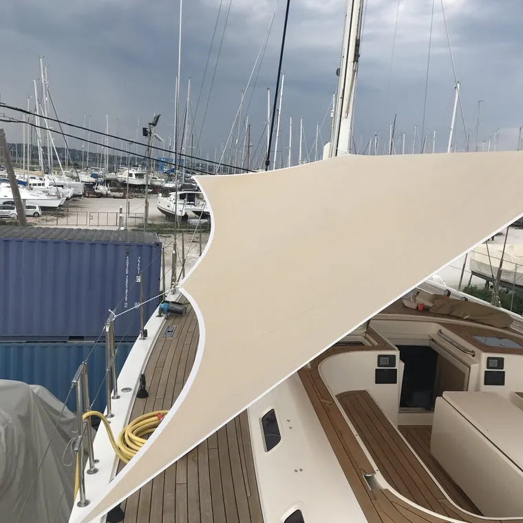 Shade sail tensioned over the side deck and coachroof of a yacht