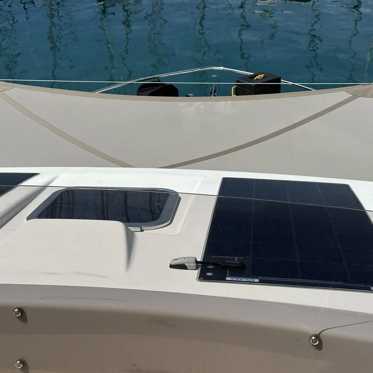 Shade sail rigged low over the coachroof and solar panels of a yacht