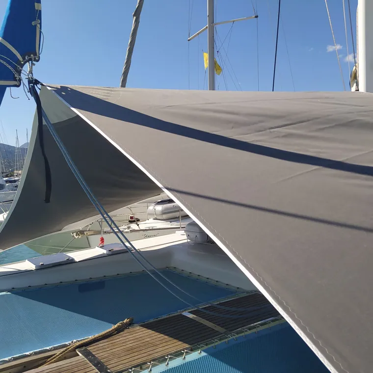 Shade sail edge and corner fitting against clear water